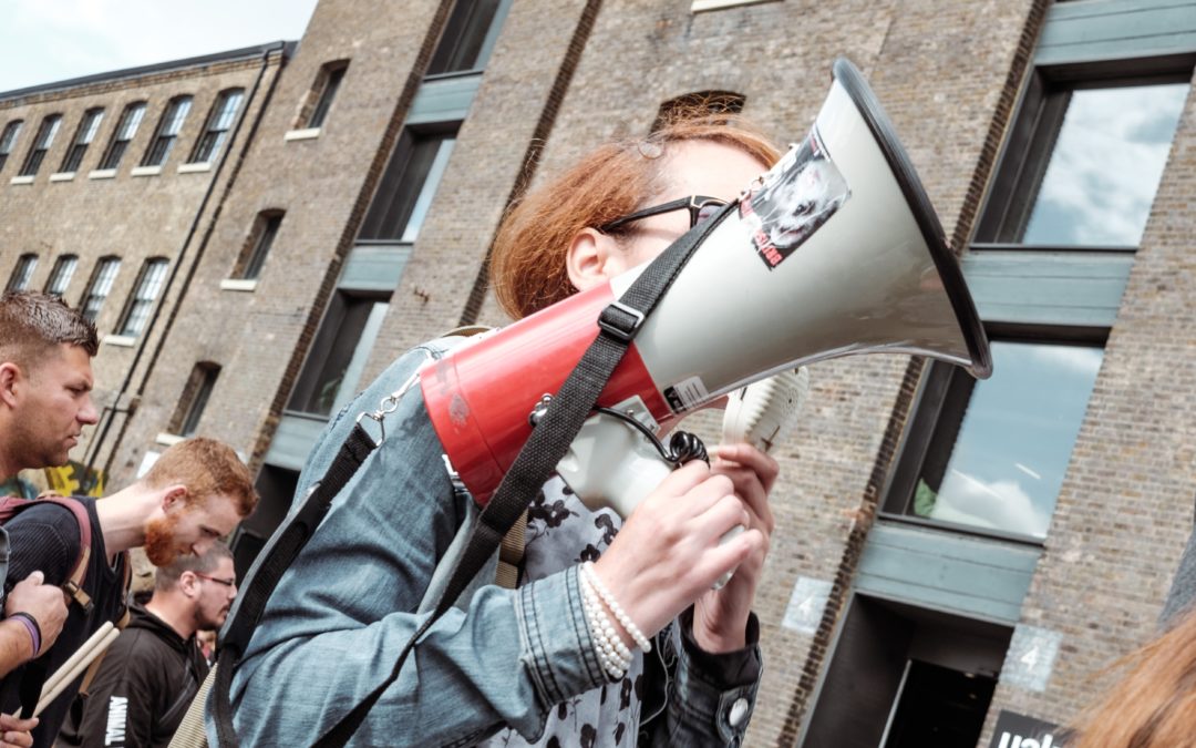 Person holding a megaphone at the front of a crowd