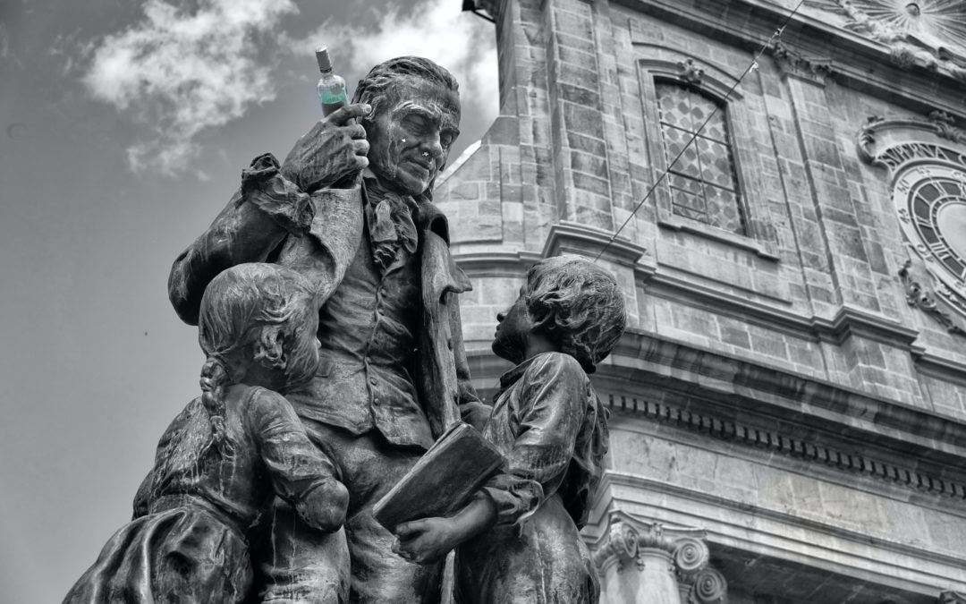 Statue of Pestalozzi the educator in Yvredon-les-Bains, with a wine bottle in hand placed there by some teenagers