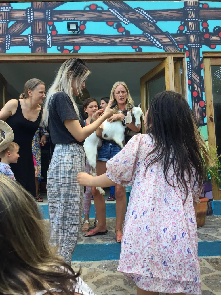 Kate, the Principal of The Hive School introducing the school goat to pupils, parents and carers on the first day of school