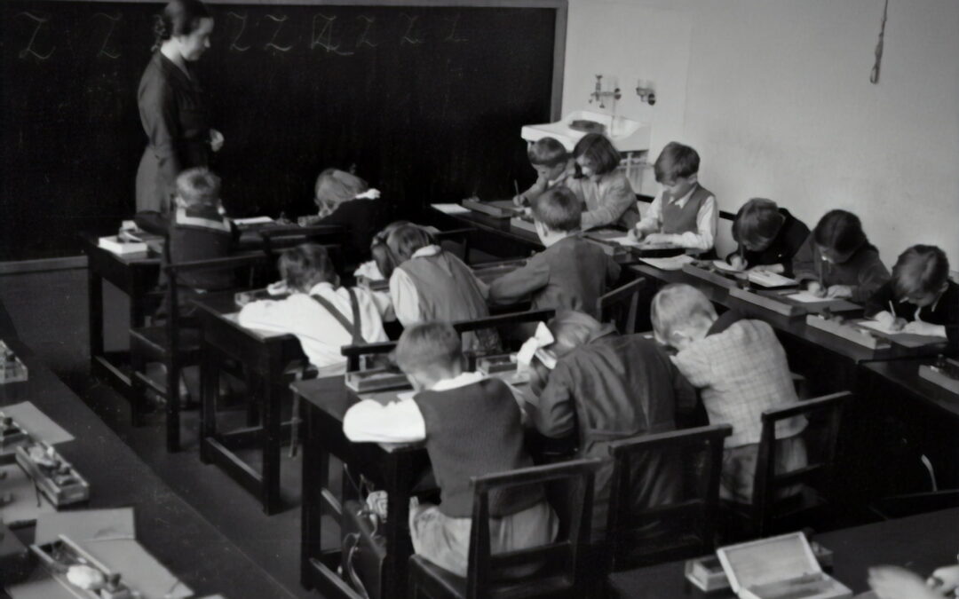 A black & white photo of an old-fashioned classroom